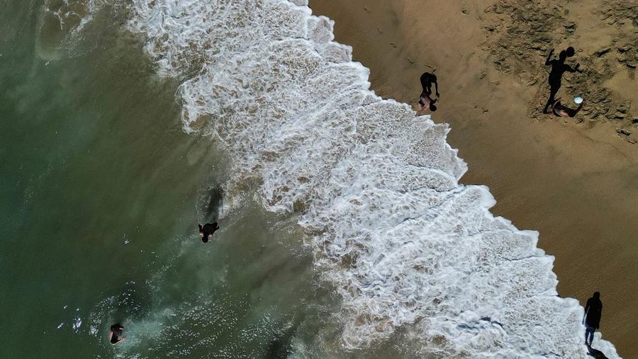 Seorang wanita melindungi putranya dari terik matahari dengan tas kardus saat gelombang panas melanda negara itu, di Vina del Mar, Cile, 19 Desember 2024. (REUTERS/Rodrigo Garrido)
