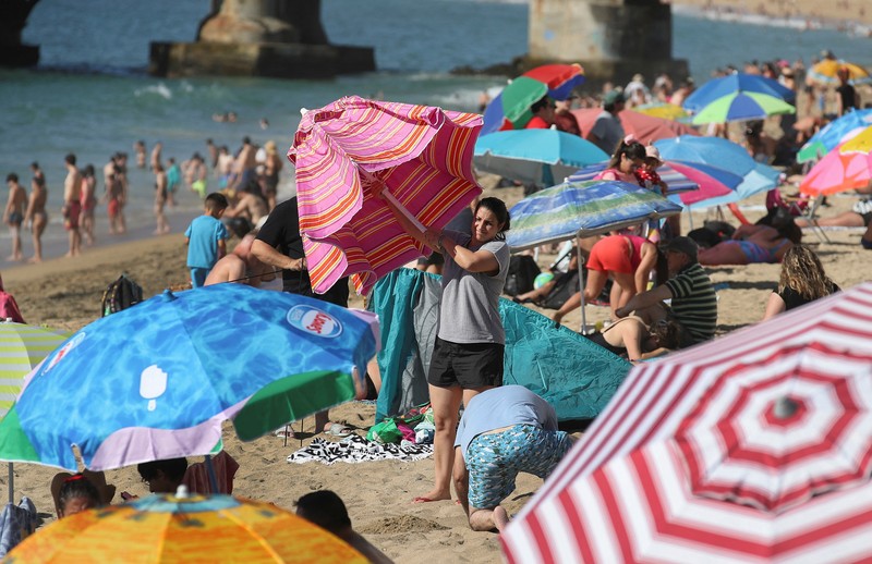 Seorang wanita melindungi putranya dari terik matahari dengan tas kardus saat gelombang panas melanda negara itu, di Vina del Mar, Cile, 19 Desember 2024. (REUTERS/Rodrigo Garrido)