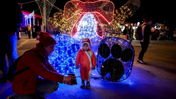 Seorang anak berpose untuk difoto di dekat dekorasi Natal di Damaskus, setelah Bashar al-Assad dari Suriah digulingkan, di Damaskus, Suriah, 19 Desember 2024. (REUTERS/Ammar Awad)