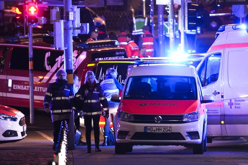 Forensics work on a damaged car sitting with its doors open after a driver plowed into a busy Christmas market in Magdeburg, Germany, early Saturday, Dec. 21, 2024. (Hendrik Schmidt/dpa via AP)