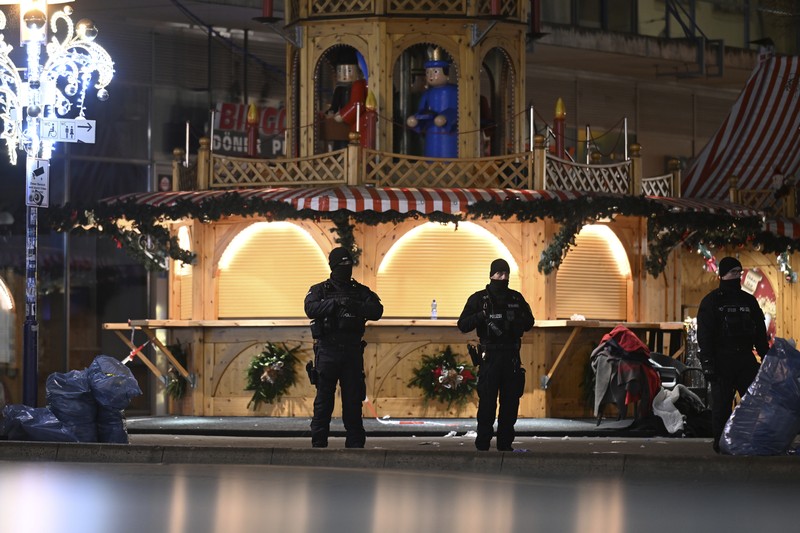 Germany Christmas Market Forensics work on a damaged car sitting with its doors open after a driver plowed into a busy Christmas market in Magdeburg, Germany, early Saturday, Dec. 21, 2024. (Hendrik Schmidt/dpa via AP)
