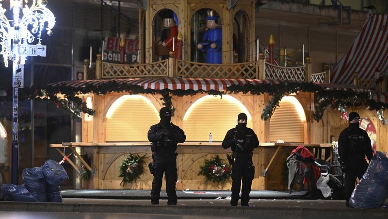 Forensics work on a damaged car sitting with its doors open after a driver plowed into a busy Christmas market in Magdeburg, Germany, early Saturday, Dec. 21, 2024. (Hendrik Schmidt/dpa via AP)