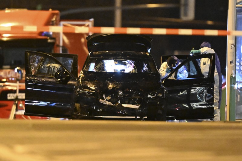 Germany Christmas Market Forensics work on a damaged car sitting with its doors open after a driver plowed into a busy Christmas market in Magdeburg, Germany, early Saturday, Dec. 21, 2024. (Hendrik Schmidt/dpa via AP)