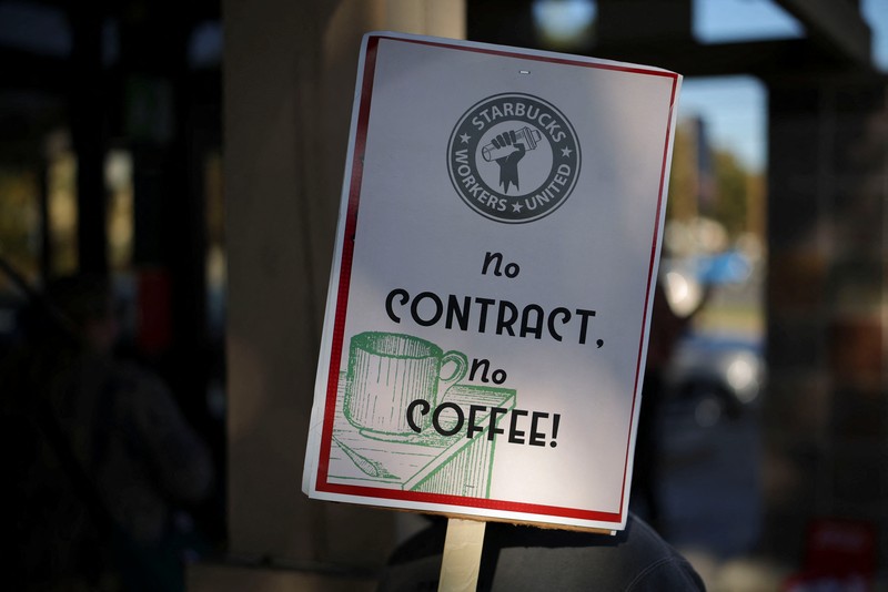 Baristas hold signs as they picket in front of a Starbucks in Burbank, California, U.S., December 20, 2024. REUTERS/Daniel Cole