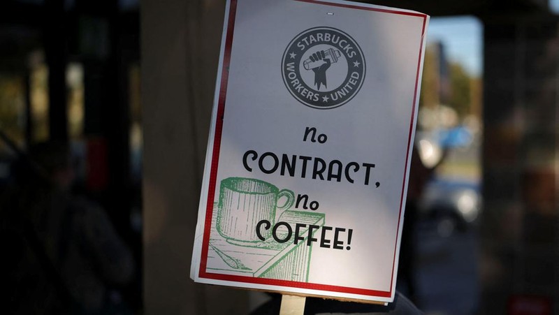 Baristas hold signs as they picket in front of a Starbucks in Burbank, California, U.S., December 20, 2024. REUTERS/Daniel Cole