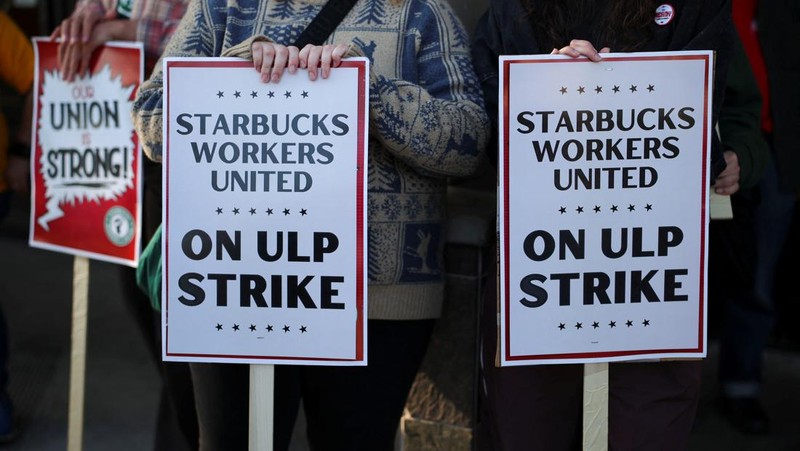 Baristas hold signs as they picket in front of a Starbucks in Burbank, California, U.S., December 20, 2024. REUTERS/Daniel Cole