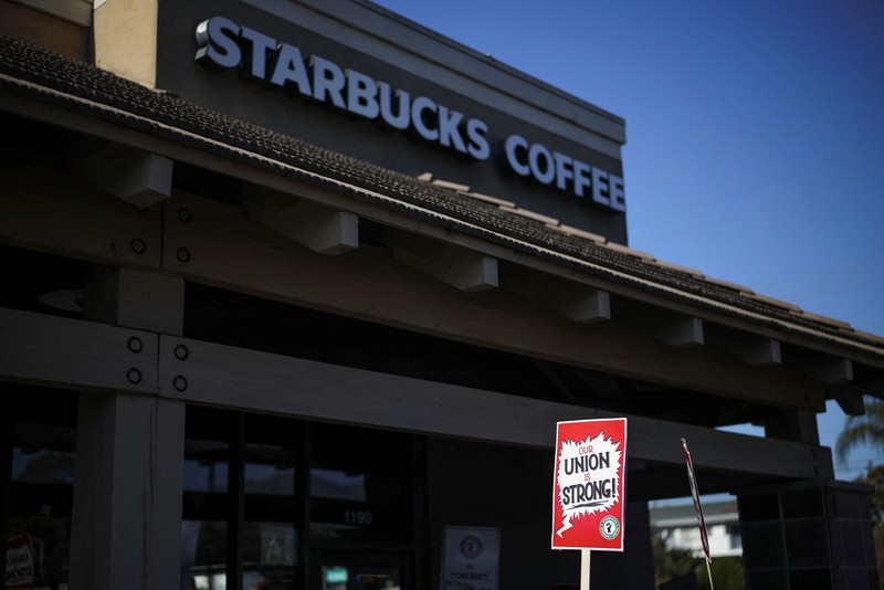 STARBUCKS-LABOR/ Baristas hold signs as they picket in front of a Starbucks in Burbank, California, U.S., December 20, 2024. REUTERS/Daniel Cole