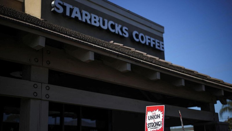 Baristas hold signs as they picket in front of a Starbucks in Burbank, California, U.S., December 20, 2024. REUTERS/Daniel Cole