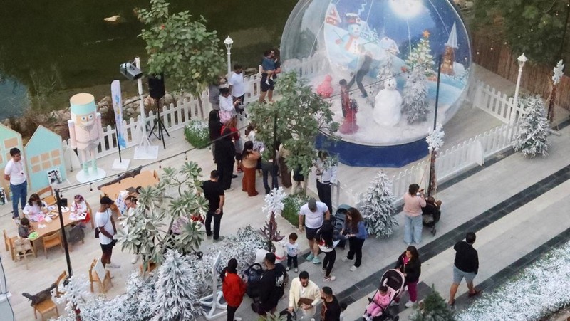 Orang-orang berjalan di sekitar dekorasi Natal di Al Barari Winter Fest, di Dubai, Uni Emirat Arab, 22 Desember 2024. (REUTERS/Abdelhadi Ramahi)