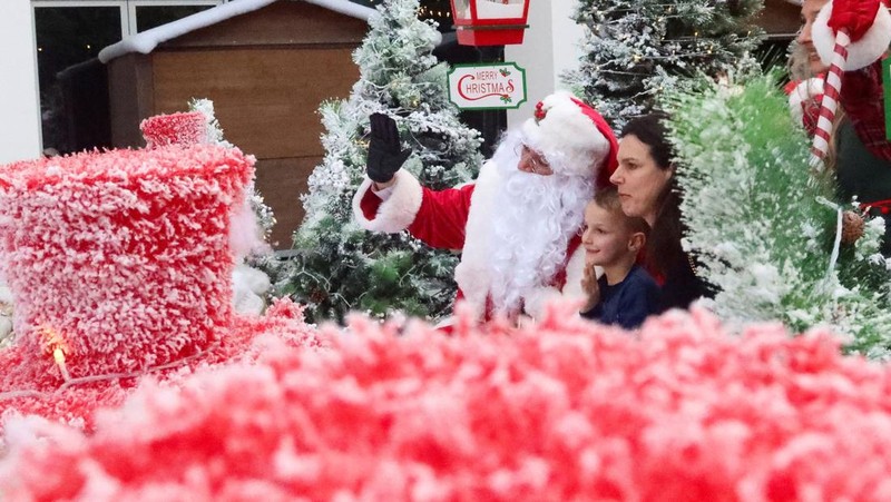 Orang-orang berjalan di sekitar dekorasi Natal di Al Barari Winter Fest, di Dubai, Uni Emirat Arab, 22 Desember 2024. (REUTERS/Abdelhadi Ramahi)