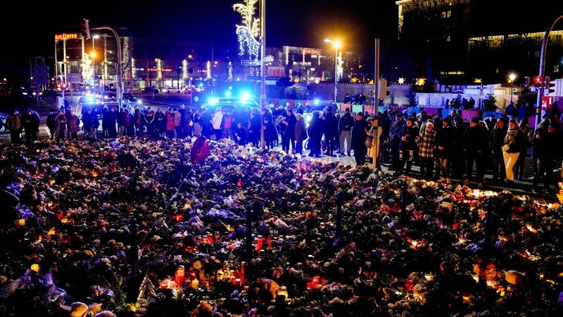 Para pelayat meletakkan bunga di dekat lokasi serangan mematikan di pasar Natal, Magdeburg, Jerman, Senin (23/12/2024). (AP Photo/Ebrahim Noroozi)