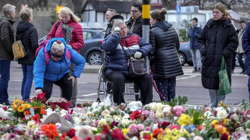 Para pelayat meletakkan bunga di dekat lokasi serangan mematikan di pasar Natal, Magdeburg, Jerman, Senin (23/12/2024). (AP Photo/Ebrahim Noroozi)