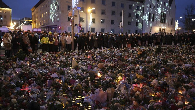 Para pelayat meletakkan bunga di dekat lokasi serangan mematikan di pasar Natal, Magdeburg, Jerman, Senin (23/12/2024). (AP Photo/Ebrahim Noroozi)