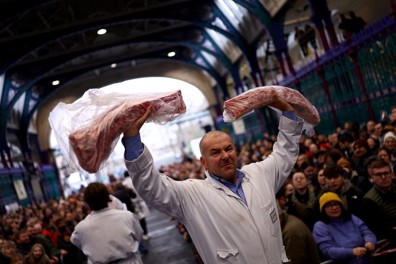 George Gardener, 11, holds a cut of meat at a pre-Christmas meat auction held by G Lawrence butchers at Smithfield Market in London, Britain, December 24, 2024. REUTERS/Hannah McKay