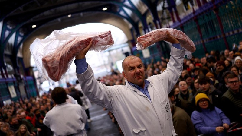 George Gardener, 11, holds a cut of meat at a pre-Christmas meat auction held by G Lawrence butchers at Smithfield Market in London, Britain, December 24, 2024. REUTERS/Hannah McKay