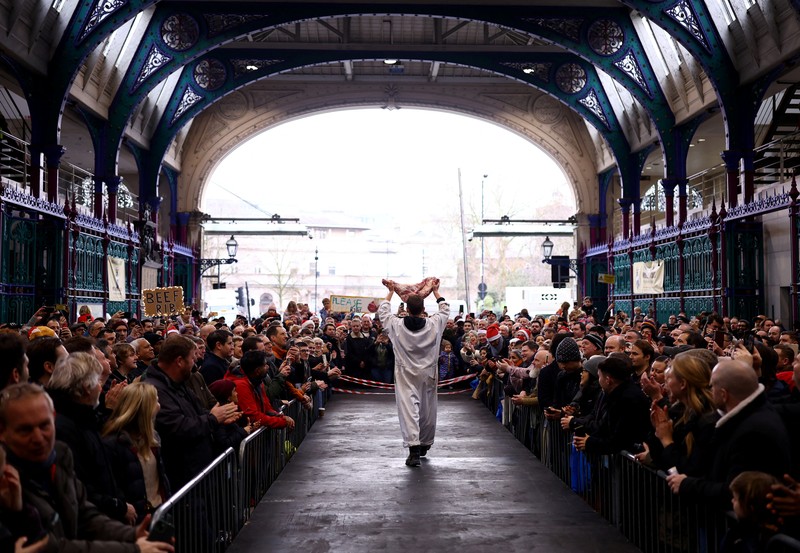 George Gardener, 11, holds a cut of meat at a pre-Christmas meat auction held by G Lawrence butchers at Smithfield Market in London, Britain, December 24, 2024. REUTERS/Hannah McKay