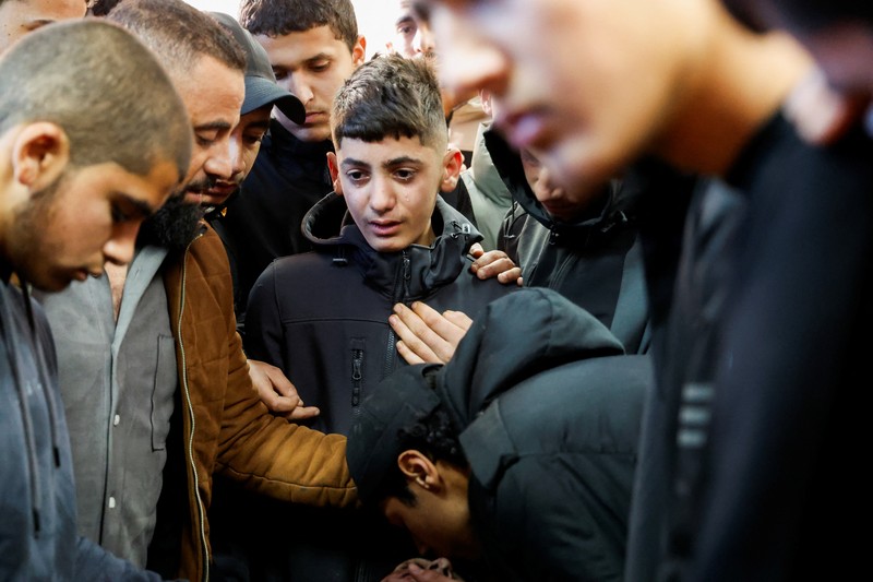ISRAEL-PALESTINIANS/WEST BANK-STRIKE-FUNERAL A gunman fires a rifle during the funeral of Rayan Bani Odeh, a Palestinian child who was killed in an Israeli airstrike, in Tammoun, near Tubas, in the Israeli-occupied West Bank, December 25, 2024. REUTERS/Raneen Sawafta TPX IMAGES OF THE DAY
