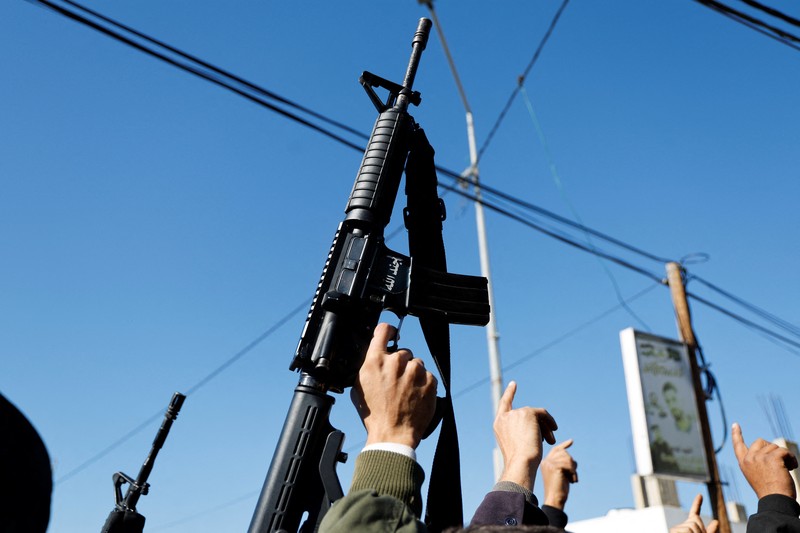 ISRAEL-PALESTINIANS/WEST BANK-STRIKE-FUNERAL A gunman fires a rifle during the funeral of Rayan Bani Odeh, a Palestinian child who was killed in an Israeli airstrike, in Tammoun, near Tubas, in the Israeli-occupied West Bank, December 25, 2024. REUTERS/Raneen Sawafta TPX IMAGES OF THE DAY