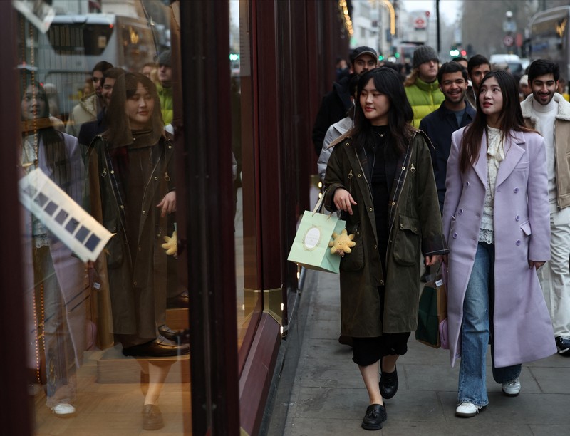 Seorang wanita menyeberang jalan dengan tas belanja di Regent St selama penjualan Boxing Day, di London, Inggris, 26 Desember 2024. Seorang wanita menyeberang jalan dengan tas belanja di Regent St selama penjualan Boxing Day, di London, Inggris, 26 Desember 2024. (REUTERS/Jaimi Joy)