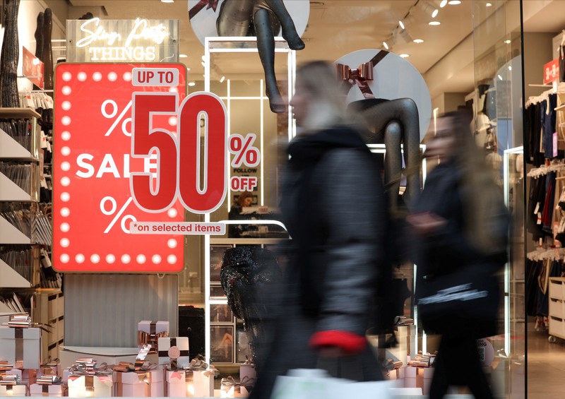Seorang wanita menyeberang jalan dengan tas belanja di Regent St selama penjualan Boxing Day, di London, Inggris, 26 Desember 2024. (REUTERS/Jaimi Joy)