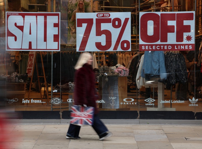 Seorang wanita menyeberang jalan dengan tas belanja di Regent St selama penjualan Boxing Day, di London, Inggris, 26 Desember 2024. (REUTERS/Jaimi Joy)
