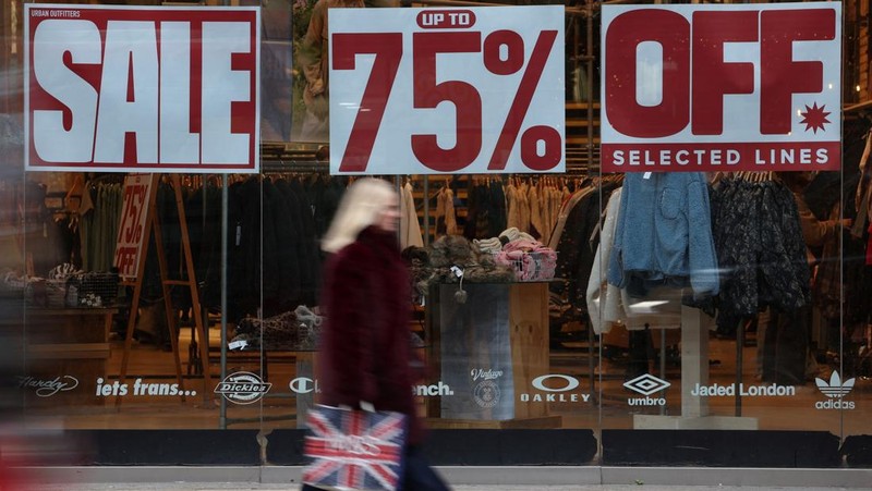 Seorang wanita menyeberang jalan dengan tas belanja di Regent St selama penjualan Boxing Day, di London, Inggris, 26 Desember 2024. (REUTERS/Jaimi Joy)