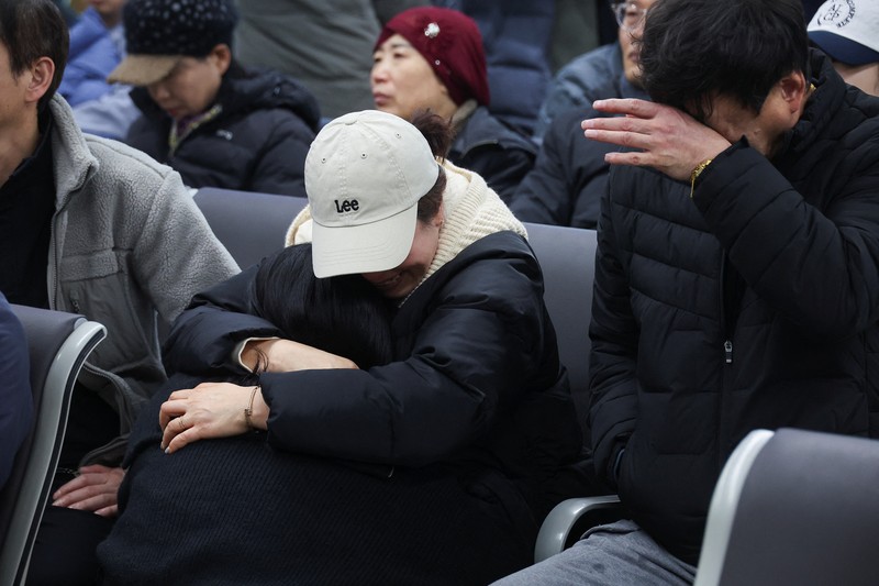 Orang-orang mendengarkan saat seorang pejabat mengungkapkan nama-nama tambahan penumpang yang tewas dalam kecelakaan pesawat di Bandara Internasional Muan, di Muan, Korea Selatan, 29 Desember 2024. Orang-orang mendengarkan saat seorang pejabat mengungkapkan nama-nama tambahan penumpang yang tewas dalam kecelakaan pesawat di Bandara Internasional Muan, di Muan, Korea Selatan, 29 Desember 2024. (REUTERS/Kim Soo-hyeon)
