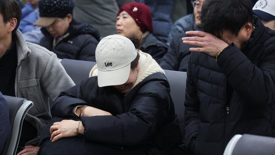 Orang-orang mendengarkan saat seorang pejabat mengungkapkan nama-nama tambahan penumpang yang tewas dalam kecelakaan pesawat di Bandara Internasional Muan, di Muan, Korea Selatan, 29 Desember 2024. (REUTERS/Kim Soo-hyeon)