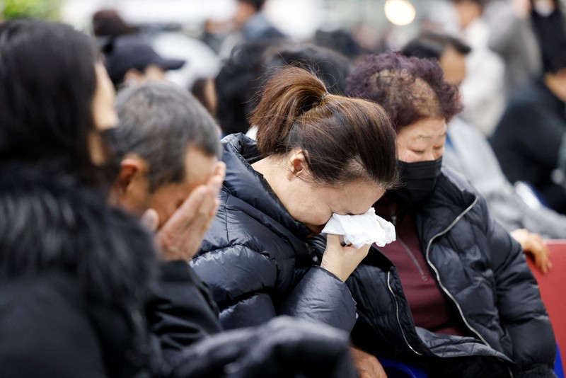 Orang-orang mendengarkan saat seorang pejabat mengungkapkan nama-nama tambahan penumpang yang tewas dalam kecelakaan pesawat di Bandara Internasional Muan, di Muan, Korea Selatan, 29 Desember 2024. Orang-orang mendengarkan saat seorang pejabat mengungkapkan nama-nama tambahan penumpang yang tewas dalam kecelakaan pesawat di Bandara Internasional Muan, di Muan, Korea Selatan, 29 Desember 2024. (REUTERS/Kim Soo-hyeon)
