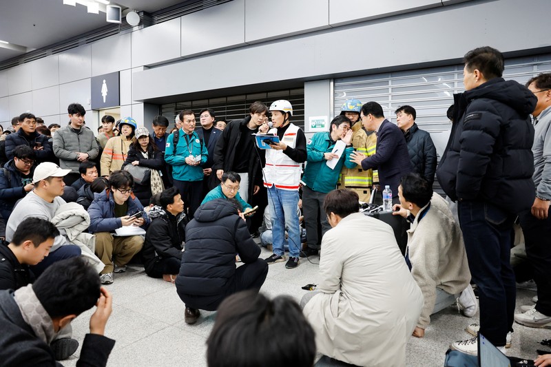 Orang-orang mendengarkan saat seorang pejabat mengungkapkan nama-nama tambahan penumpang yang tewas dalam kecelakaan pesawat di Bandara Internasional Muan, di Muan, Korea Selatan, 29 Desember 2024. Orang-orang mendengarkan saat seorang pejabat mengungkapkan nama-nama tambahan penumpang yang tewas dalam kecelakaan pesawat di Bandara Internasional Muan, di Muan, Korea Selatan, 29 Desember 2024. (REUTERS/Kim Soo-hyeon)