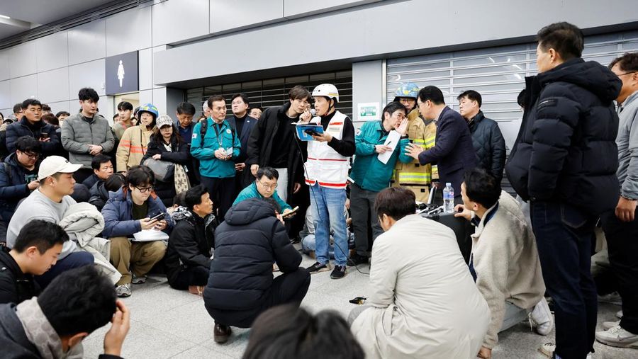 Orang-orang mendengarkan saat seorang pejabat mengungkapkan nama-nama tambahan penumpang yang tewas dalam kecelakaan pesawat di Bandara Internasional Muan, di Muan, Korea Selatan, 29 Desember 2024. (REUTERS/Kim Soo-hyeon)