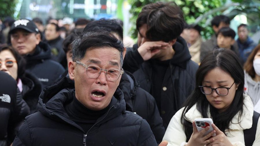 Orang-orang mendengarkan saat seorang pejabat mengungkapkan nama-nama tambahan penumpang yang tewas dalam kecelakaan pesawat di Bandara Internasional Muan, di Muan, Korea Selatan, 29 Desember 2024. (REUTERS/Kim Soo-hyeon)