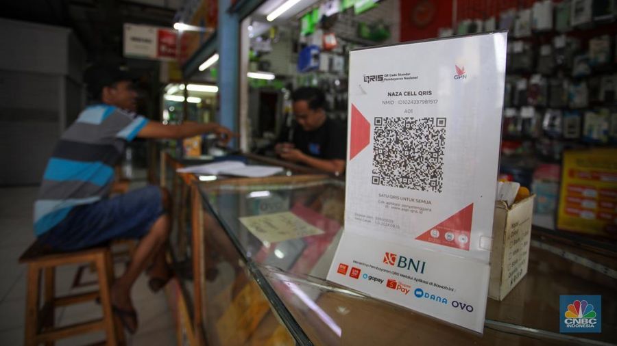 Pembeli memindai kode batang pembayaran Quick Response Code Indonesian Standard (QRIS) saat melakukan transaksi di Pasar Santa, Jakarta, Senin (30/12/2024). (CNBC Indonesia/Faisal Rahman)