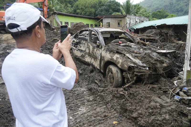 YEAR-END/2024-PHOTOS-BEST A worker looks at a car stuck on a broken road in the aftermath of an earthquake, near Anamizu, Japan, January 3, 2024. REUTERS/Kim Kyung-Hoon SEARCH