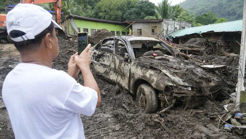 A worker looks at a car stuck on a broken road in the aftermath of an earthquake, near Anamizu, Japan, January 3, 2024. REUTERS/Kim Kyung-Hoon          SEARCH 