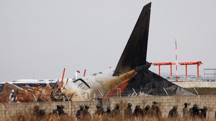 Military personnel work at the site where an aircraft of Jeju Air went off the runway and crashed at Muan International Airport, in Muan, South Korea, December 30, 2024. REUTERS/Kim Soo-hyeon REFILE - CORRECTING ACTION FROM