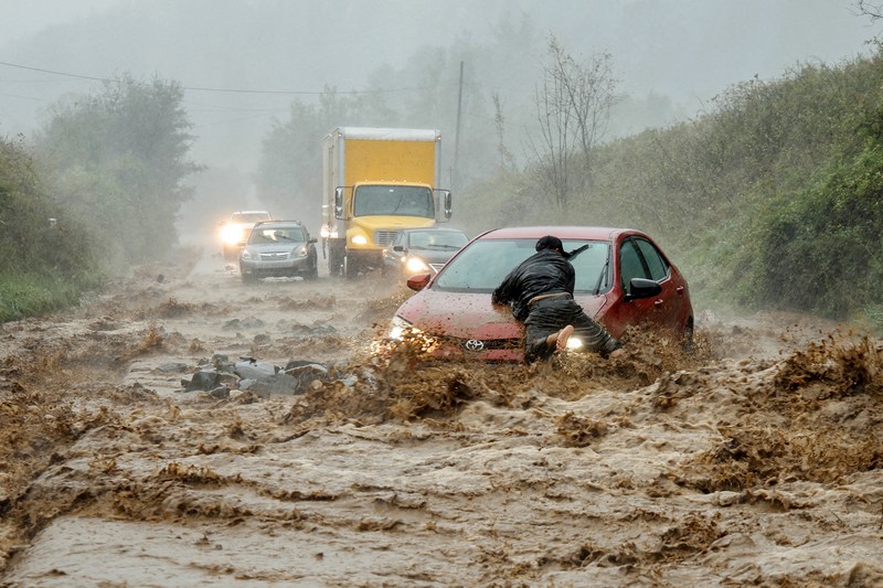 YEAR-END/2024-PHOTOS-BEST A worker looks at a car stuck on a broken road in the aftermath of an earthquake, near Anamizu, Japan, January 3, 2024. REUTERS/Kim Kyung-Hoon SEARCH