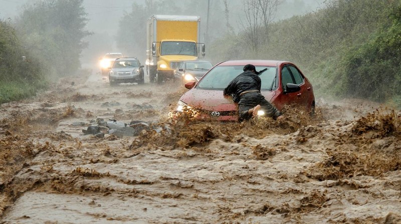 A worker looks at a car stuck on a broken road in the aftermath of an earthquake, near Anamizu, Japan, January 3, 2024. REUTERS/Kim Kyung-Hoon          SEARCH 