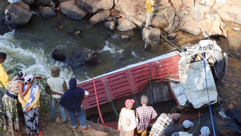 Pelayat berdiri di samping truk Isuzu yang hancur setelah jatuh dari jembatan di Desa Bona, Negara Bagian Sidama di Ethiopia, 30 Desember 2024. (REUTERS/Stringer)