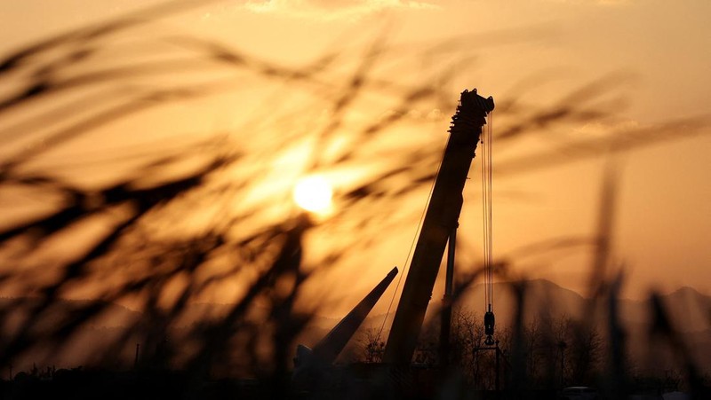 A bird flies by as the sun rises behind the aircraft that crashed after it went off the runway, at Muan International Airport, in Muan, South Korea, December 31, 2024. REUTERS/Kim Hong-Ji