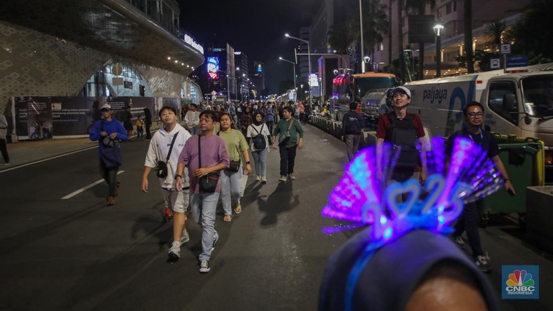 Warga memadati kawasan Bundaran Hotel Indonesia (HI) jelang malam pergantian tahun baru di Jakarta, Selasa (31/12/2024). (CNBC Indonesia/Faisal Rahman)