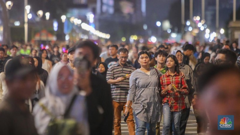 Warga memadati kawasan Bundaran Hotel Indonesia (HI) jelang malam pergantian tahun baru di Jakarta, Selasa (31/12/2024). (CNBC Indonesia/Faisal Rahman)