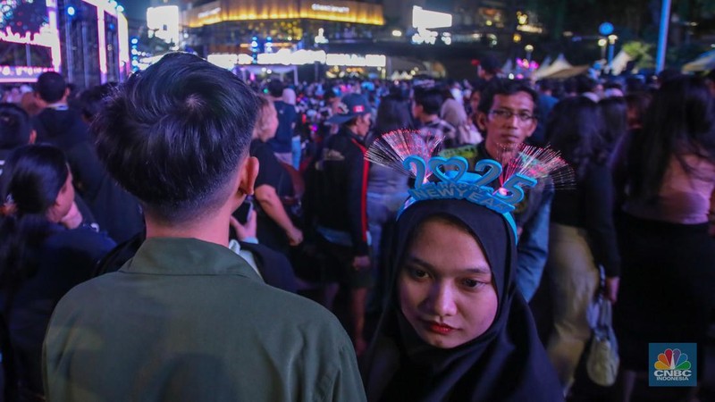 Warga memadati kawasan Bundaran Hotel Indonesia (HI) jelang malam pergantian tahun baru di Jakarta, Selasa (31/12/2024). (CNBC Indonesia/Faisal Rahman)