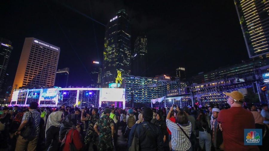 Warga memadati kawasan Bundaran Hotel Indonesia (HI) jelang malam pergantian tahun baru di Jakarta, Selasa (31/12/2024). (CNBC Indonesia/Faisal Rahman)
