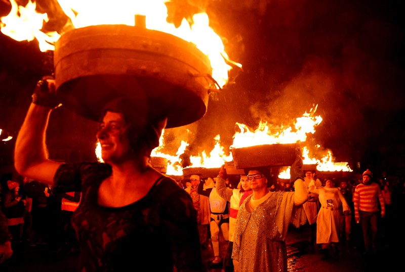 Orang-orang mengambil bagian dalam Festival Tar Barrel Allendale tahunan, di Allendale, Inggris utara, Inggris, 31 Desember 2024. Orang-orang mengambil bagian dalam Festival Tar Barrel Allendale tahunan, di Allendale, Inggris utara, Inggris, 31 Desember 2024. (REUTERS/Lee Smith)