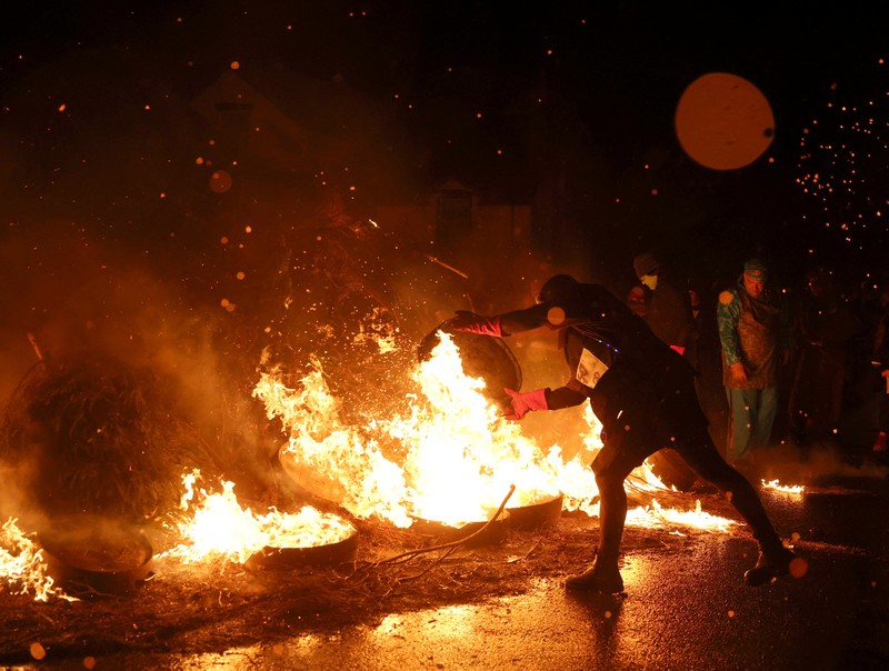Orang-orang mengambil bagian dalam Festival Tar Barrel Allendale tahunan, di Allendale, Inggris utara, Inggris, 31 Desember 2024. Orang-orang mengambil bagian dalam Festival Tar Barrel Allendale tahunan, di Allendale, Inggris utara, Inggris, 31 Desember 2024. (REUTERS/Lee Smith)