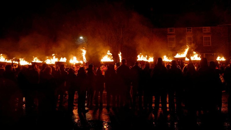 Orang-orang mengambil bagian dalam Festival Tar Barrel Allendale tahunan, di Allendale, Inggris utara, Inggris, 31 Desember 2024. (REUTERS/Lee Smith)