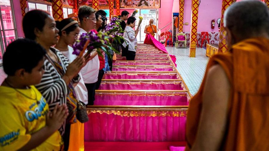 Para penyembah berdoa sambil berdiri di dalam peti mati untuk menyingkirkan nasib buruk dan terlahir kembali untuk awal yang baru di Tahun Baru di sebuah kuil di Nonthaburi, di pinggiran Bangkok, Thailand, 1 Januari 2025. (REUTERS/Athit Perawongmetha)