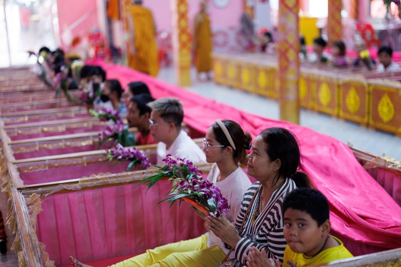 Para penyembah berdoa sambil berdiri di dalam peti mati untuk menyingkirkan nasib buruk dan terlahir kembali untuk awal yang baru di Tahun Baru di sebuah kuil di Nonthaburi, di pinggiran Bangkok, Thailand, 1 Januari 2025. Para penyembah berdoa sambil berdiri di dalam peti mati untuk menyingkirkan nasib buruk dan terlahir kembali untuk awal yang baru di Tahun Baru di sebuah kuil di Nonthaburi, di pinggiran Bangkok, Thailand, 1 Januari 2025. (REUTERS/Athit Perawongmetha)