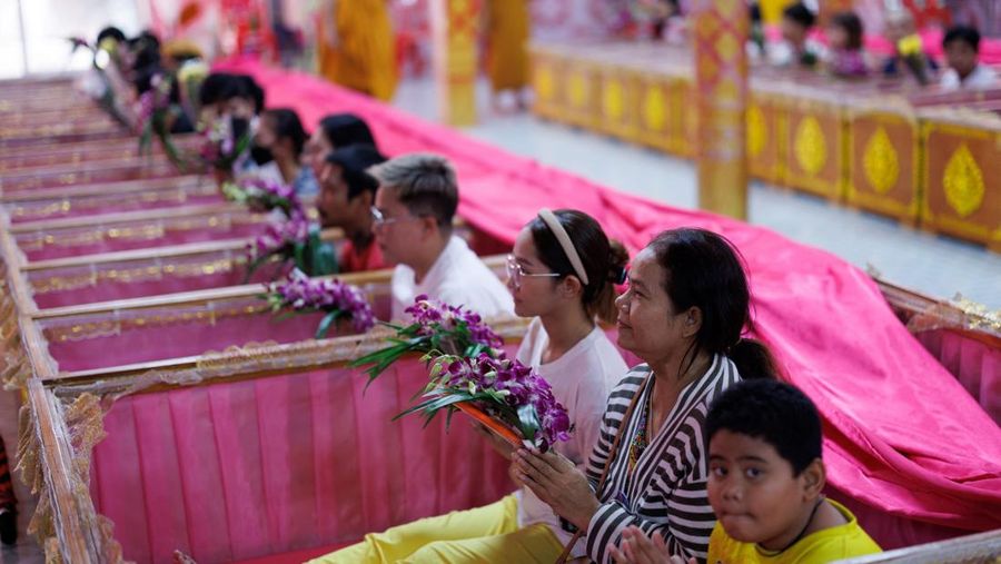 Para penyembah berdoa sambil berdiri di dalam peti mati untuk menyingkirkan nasib buruk dan terlahir kembali untuk awal yang baru di Tahun Baru di sebuah kuil di Nonthaburi, di pinggiran Bangkok, Thailand, 1 Januari 2025. (REUTERS/Athit Perawongmetha)